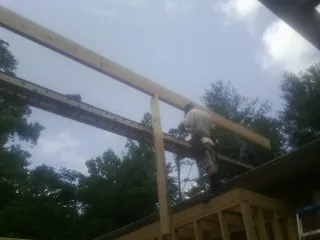 Carpenter setting a ridge beam over a new addition frame — Ice Dam Removal by Roofing Brothers in Kouts