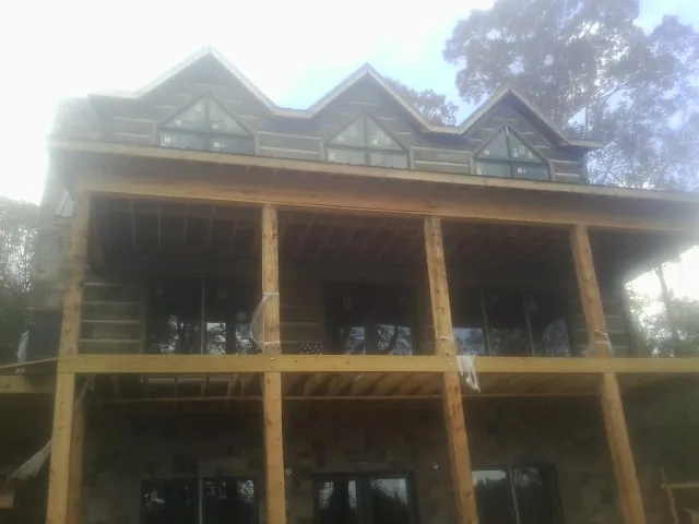 Dormers and porch framing on a large log home under construction — Roof Coating work by our crew in Kouts